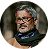 Elderly man with glasses and a beard, smiling warmly.