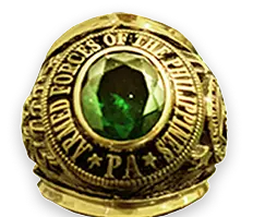 Gold ring with a large green gemstone and engraved text.