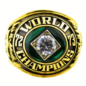 A gold championship ring with a large diamond and the words 'World Champions'.