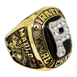 A gold and black championship ring with intricate details and diamonds.