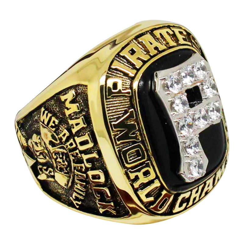 A gold and black championship ring with intricate details and diamonds.
