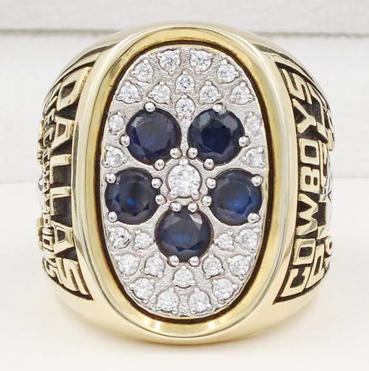 Gold Cowboys championship ring with blue stones and diamonds.